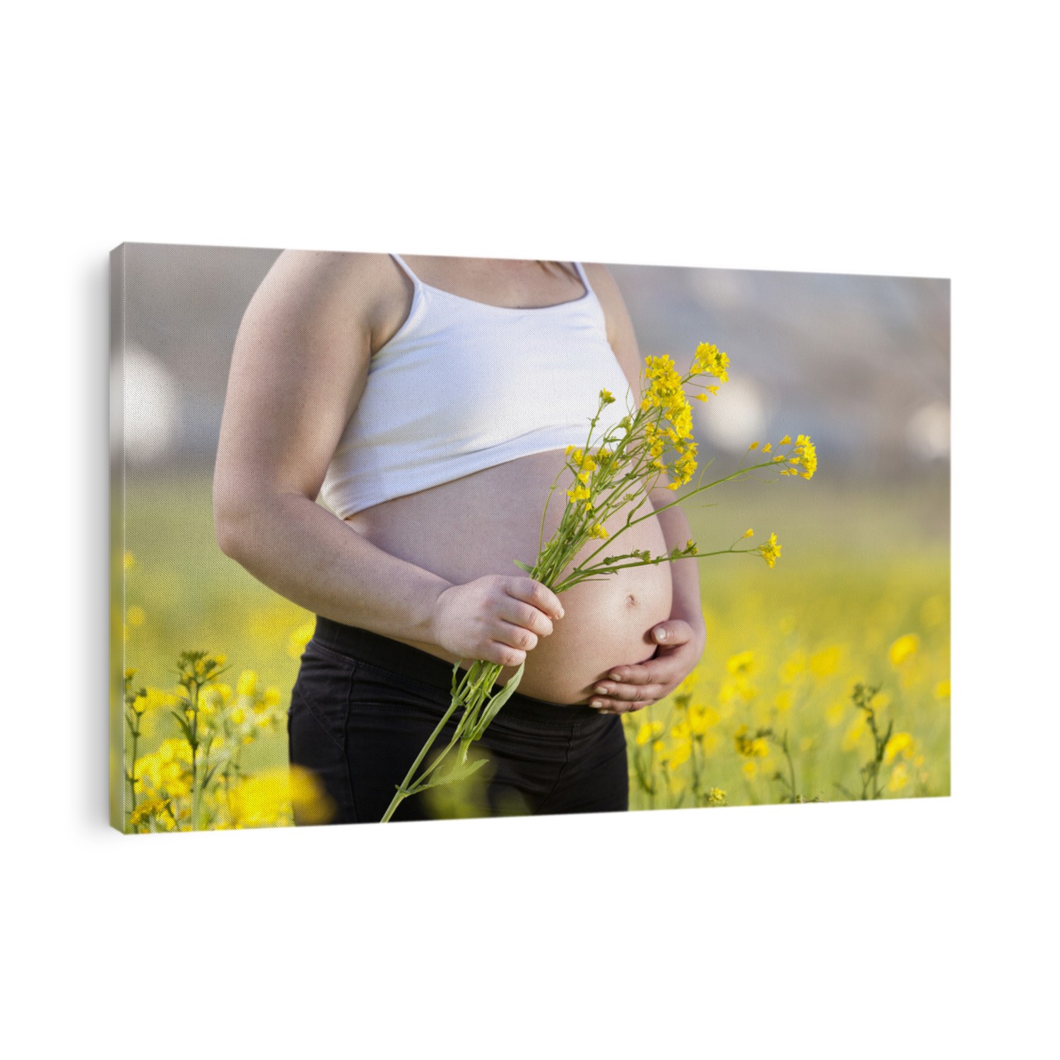 Pregnant woman holding wildflowers at the park